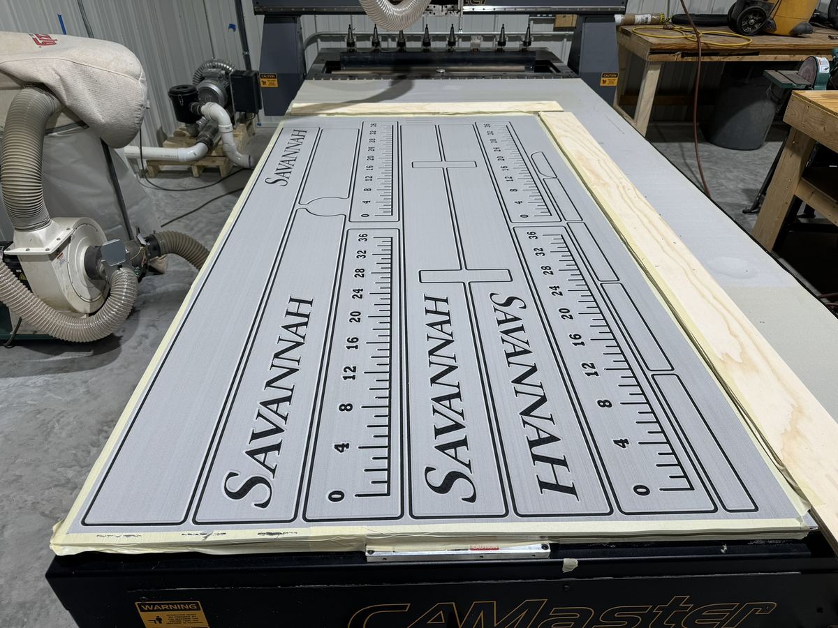 CNC machine cutting gray EVA foam boat deck panels with the boat name Savannah and fish rulers