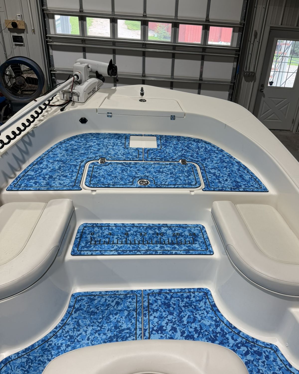 Bow of a Sundance bay boat with custom blue camo EVA foam decking and fish ruler installed by Deck Boss Marine